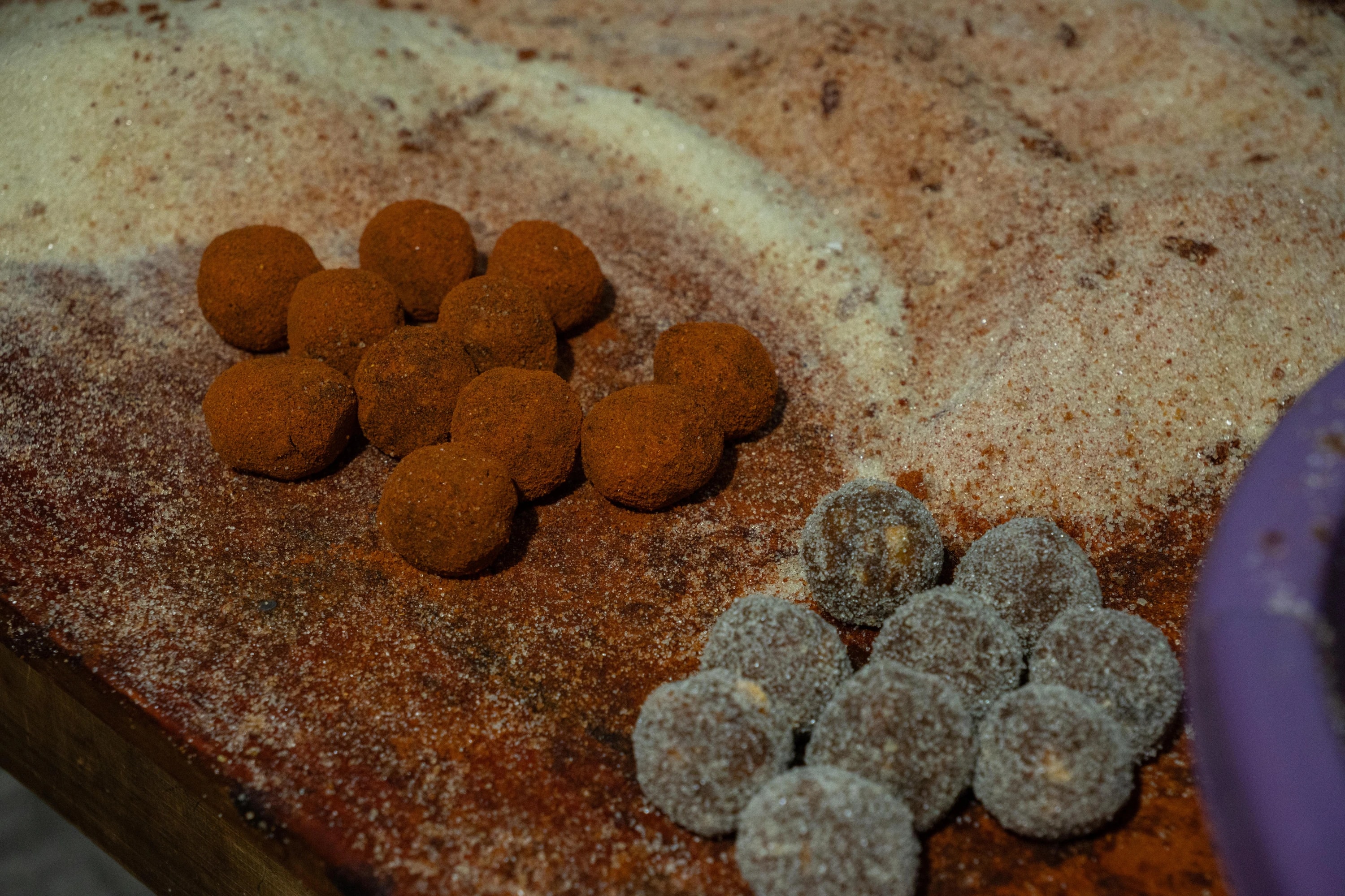 Dulces redondos cubiertos de azúcar y polvo marrón sobre una mesa de madera